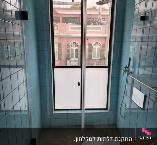 מקלחת עם אריחים כחולים וראש מקלחת עגול